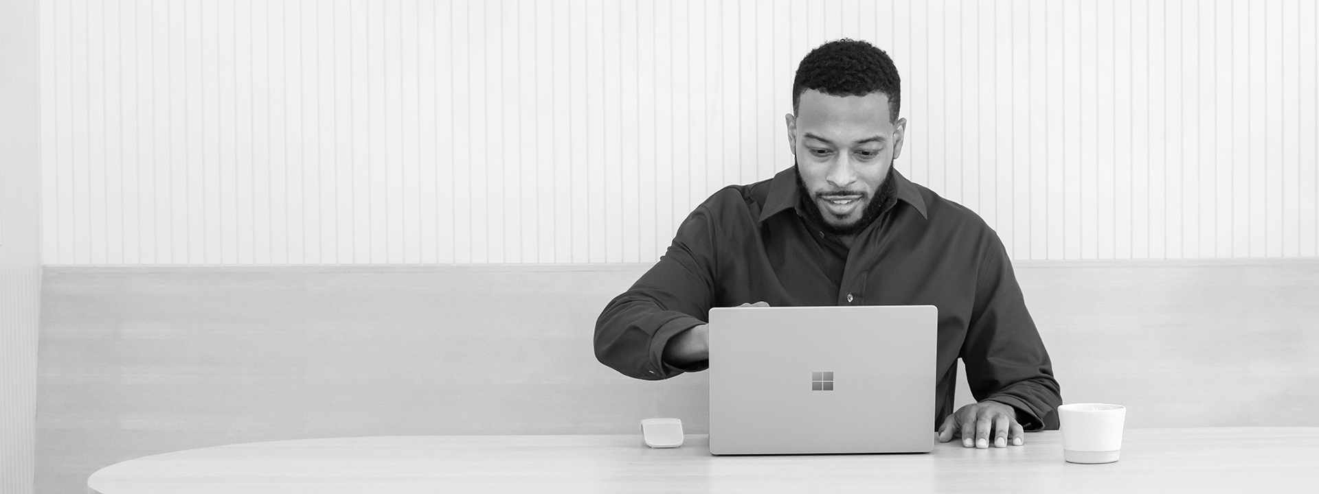 A man sitting at a desk looking at his laptop screen