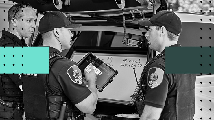 Three police officers looking at a tablet