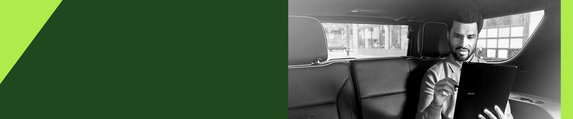 A man sitting in a car holding a tablet